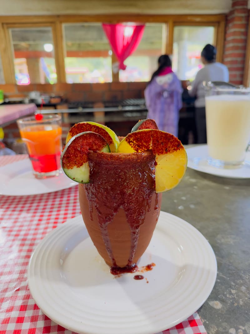 Cantarito servido en jarro de barro con abanico de naranja, limón y pepino