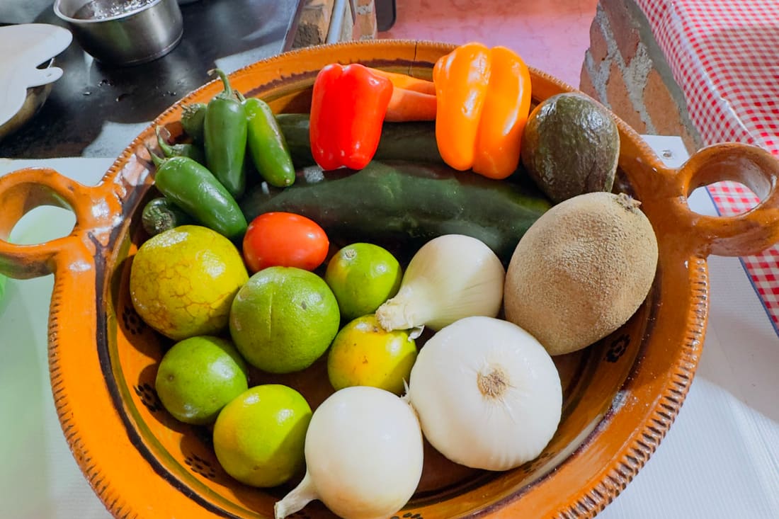 Canastas de barro con limones, jitomates, cebolla y chiles