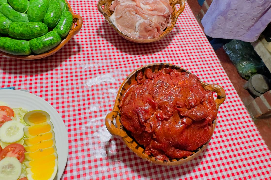 Plato servido con carne, guarnición y salsa sobre mantel de cuadros