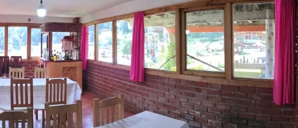 Vista del interior del salón con sus ventanales al bosque