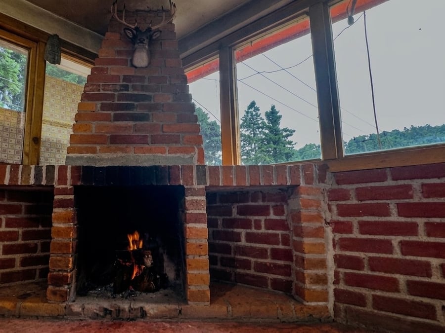 Chimenea de ladrillo encendida dentro del salón