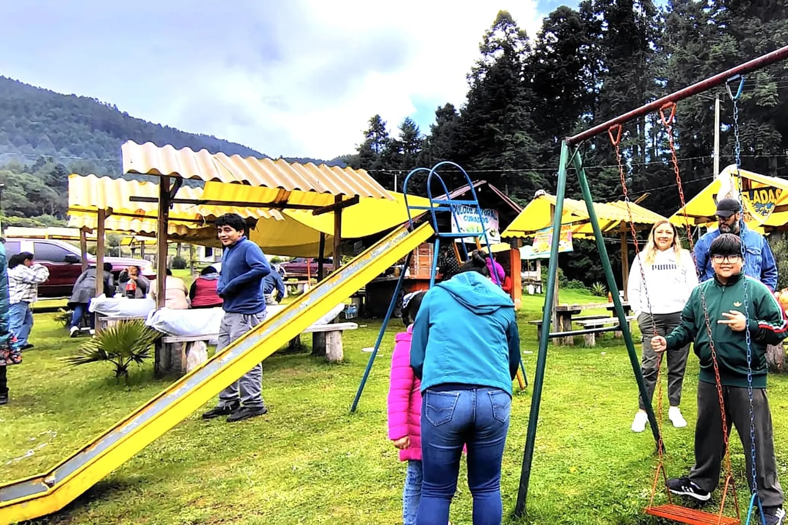 Visitantes en el área de columpios junto a las palapas