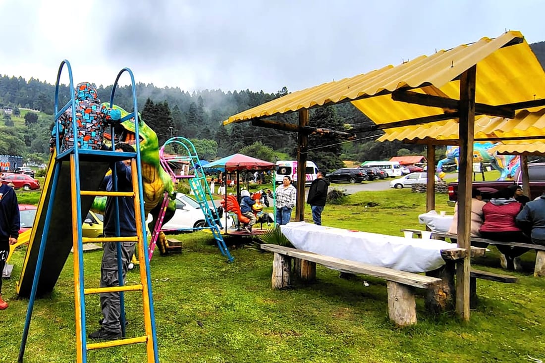 Niños jugando en la resbaladilla y los columpios del área infantil