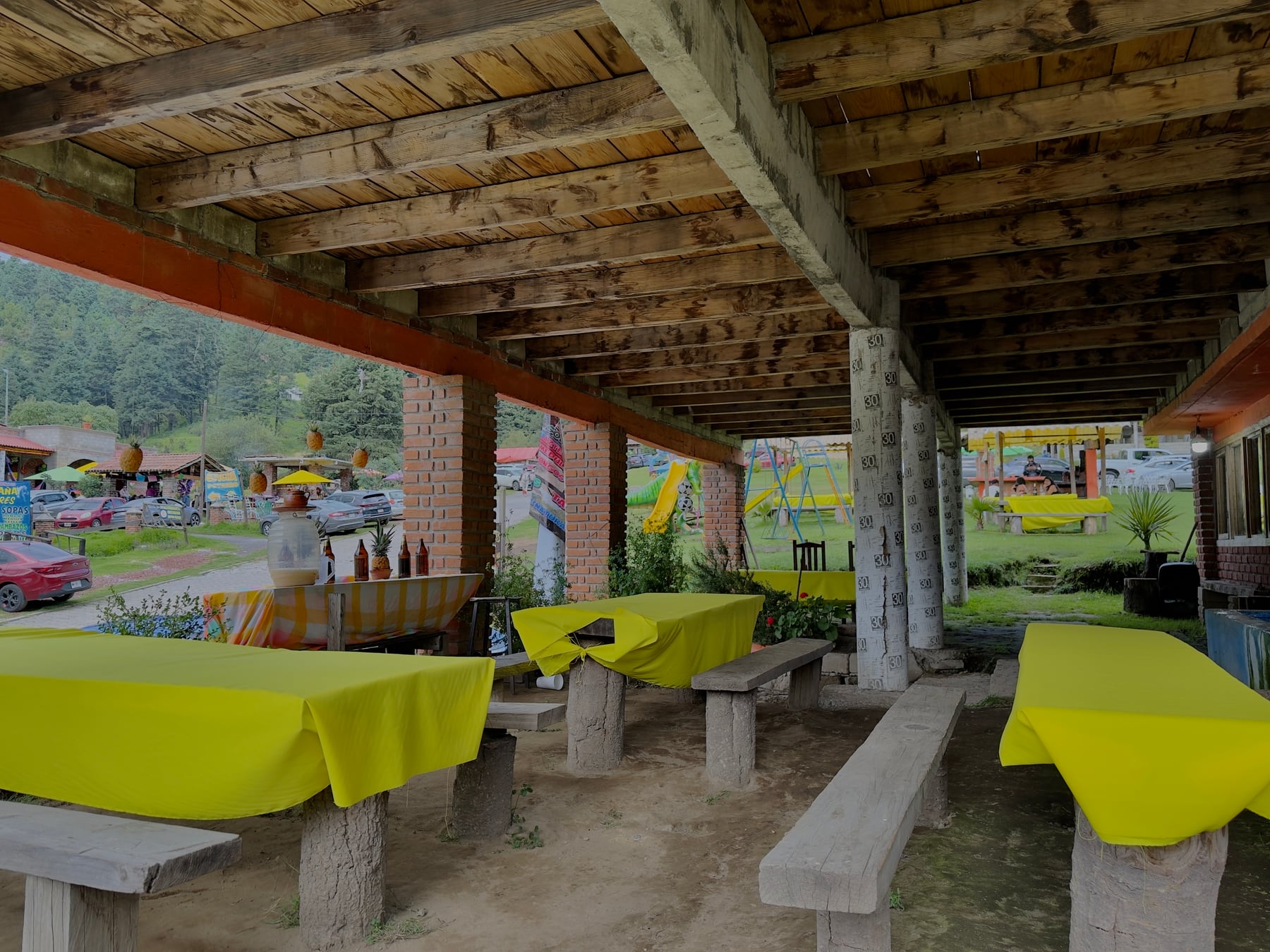 Área exterior de la hacienda con las mesas vestidas y el bosque al fondo
