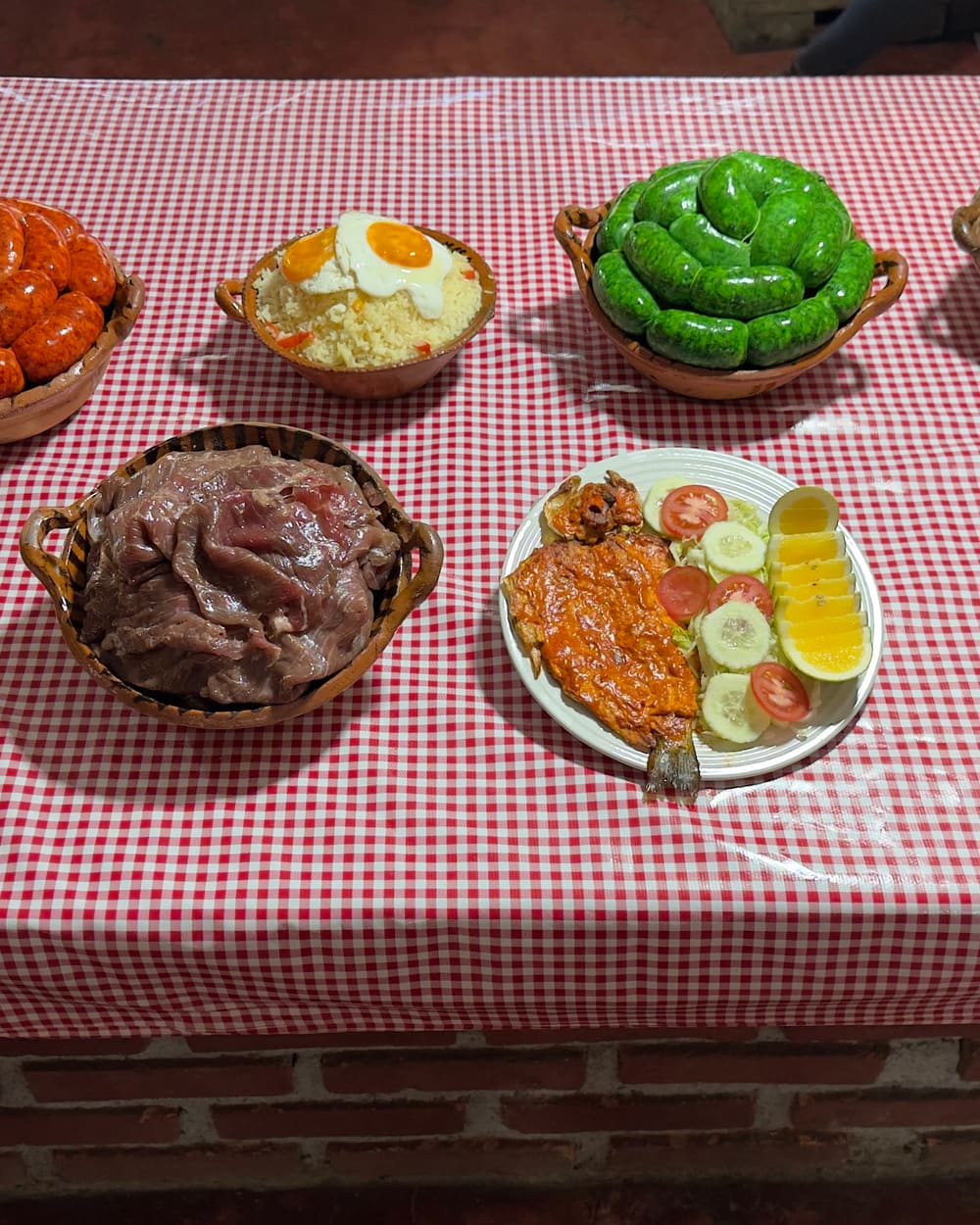 Mesa con cecina, chorizo verde, chorizo rojo y queso antes de ir a la parrilla